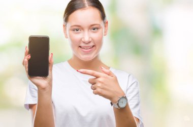 Genç güzel beyaz kadın gösteren smartphone ekran üzerinde izole arka el ve parmak ile işaret çok mutlu
