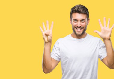 Yakışıklı delikanlı gösterilen ve parmakları ile işaret izole arka plan üzerinde numara 9 kendinden emin ve mutlu gülümseyerek süre.