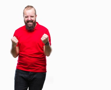 Üzerinde kırmızı gömlek giyen genç beyaz hipster adam arka plan çok mutlu ve heyecanlı kaldırdı, silah ile kazanan jest yapıyor gülümseyen ve başarı için çığlık izole. Kutlama kavramı.