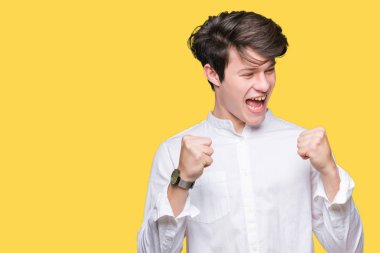 Gülümseyen ve başarı için çığlık genç yakışıklı iş adamı izole arka plan çok mutlu ve heyecanlı kaldırdı, silah ile kazanan jest yapıyor üzerinde. Kutlama kavramı.