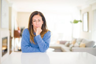Güzel orta yaş kadın evde seyir yorgun ve çapraz kolları olan depresyon sorunları ile sıkılmış düşünme.