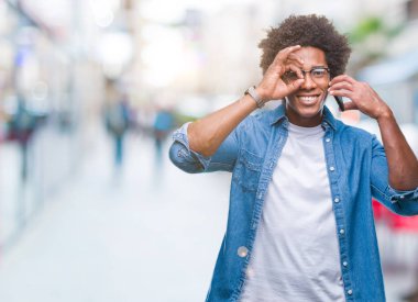 Mutlu yüz el parmaklarının arasından seyir göz üzerinde ok işaretiyle yapıyor gülümseyen izole arka plan üzerinde telefonda konuşurken Afro Amerikalı adam
