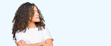 Kıvırcık saçlı giyen ile genç güzel kadın beyaz t-shirt gülümseyen yan kolları olan isteyen ikna ve kendine güvenen geçti