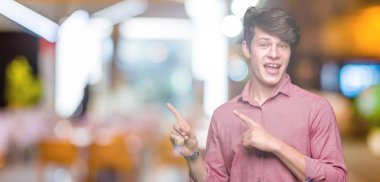 Genç yakışıklı iş adamı gülümseyen ve iki elleri ve parmakları ile tarafına işaret kamera bakarak izole arka plan üzerinde.