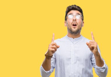 Yakışıklı delikanlı izole arka plan üzerinden hayran ve yukarıya bakıp parmakları ile işaret şaşırttı ve silah kaldırdı.