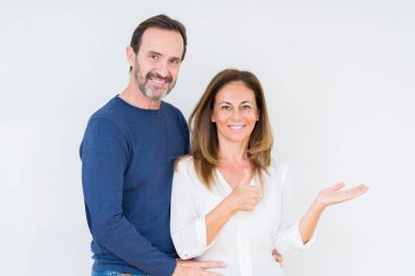 Güzel orta yaş kaç aşk içinde arka plan gösteren palm el izole ve mutlu ve neşeli gülümseyen thumbs up, ok hareketi ile yapıyor