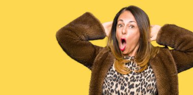 Güzel orta yaş zarif kadın giyiyor vizon deli ceket ve baş, korkuyor ve açık ağzı ile şok sürpriz elleriyle korkuttu