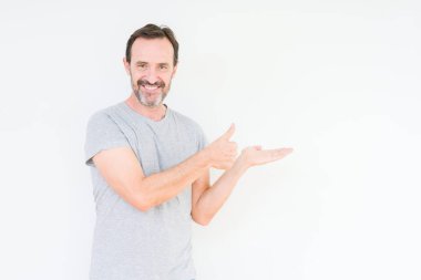 İzole arka plan gösteren palm el ve iş tamam jestle başparmak yukarı, gülümseyen mutlu ve neşeli yakışıklı üst düzey adam