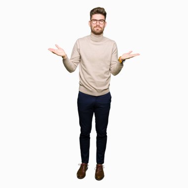 Gözlük clueless ve şaşkın bir ifadeyle kollar ve eller kaldırdı giyen genç yakışıklı iş adam. Şüphe kavramı.