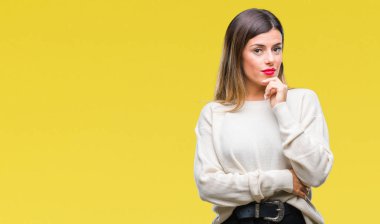 Genç güzel kadın rahat beyaz kazak emin çapraz kollar ve çeneme kaldırdı el ile gülümseme ile kameraya bakarak izole arka plan üzerinde. Pozitif düşünce.