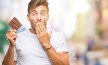 Hata, korku, sessizlik içinde gizli kavramı korkmuş ifade için utanç ile izole arka kapak ağız el ile üzerinden çikolata yeme genç yakışıklı adam şok