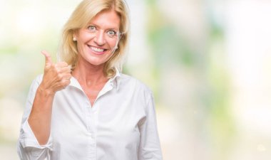 Orta yaş sarışın iş kadın hareketi el ile mutlu yaşasın yapıyor izole arka plan yüzünden. Kameraya bakarak başarı gösteren ile ifade onaylama.