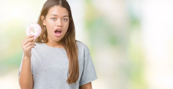 Junge Schöne Frau Isst Rosa Donut Über Isoliertem Hintergrund Erschrocken — Stockfoto