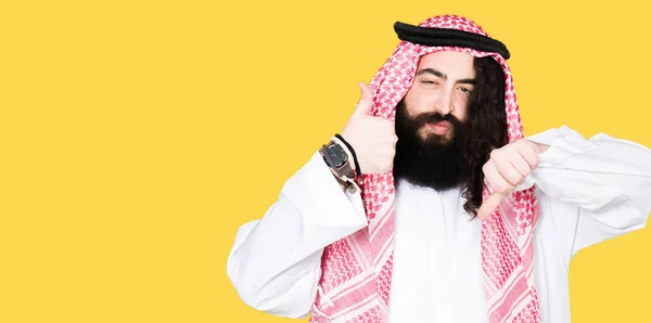 阿拉伯商人留着长发 戴着传统的 Keffieh 围巾做大拇指上下 分歧和同意表达 疯狂的冲突 — 图库照片