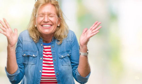 Orta yaş sarışın kadın deli ve silah ile başarı için deli kutluyor izole arka plan üzerinde kaldırdı ve heyecanlı çığlık gözler kapalı. Kazanan kavramı