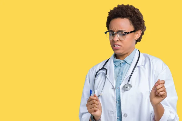 Young african american doctor woman wearing medical coat over isolated background disgusted expression, displeased and fearful doing disgust face because aversion reaction. With hands raised. Annoying concept.