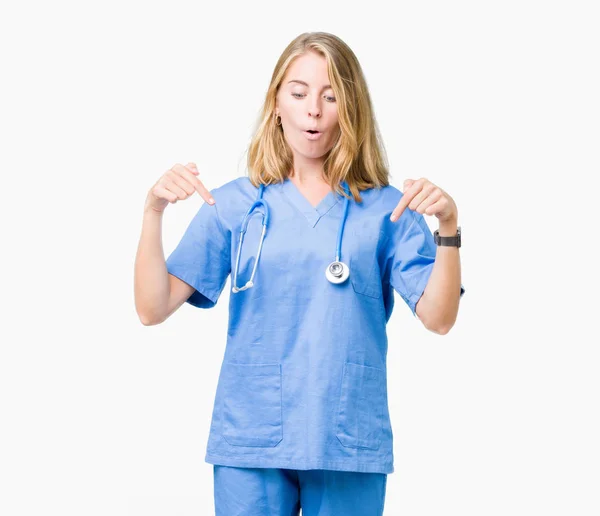 分離の上医療制服を着て美しい女医女性ダウン表示広告 驚いた顔 口を開けて指でポインティングを背景します — ストック写真