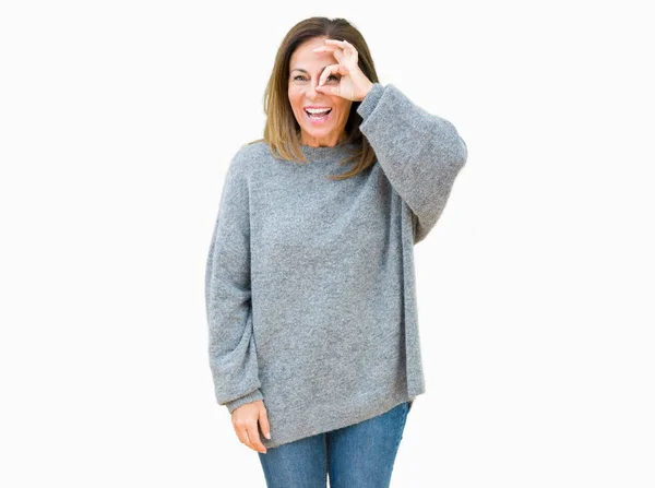 幸せそうな顔で指を通して見る目の手で のジェスチャーを行う分離の背景に冬のセーターを着て美しい中年女性 — ストック写真