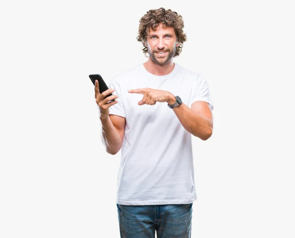 英俊的西班牙人模型发送消息短信使用智能手机在孤立的背景非常愉快的指向与手和手指 — 图库照片