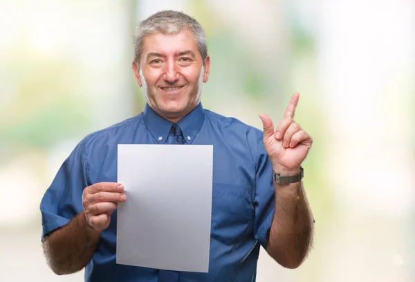 Pěkný Starší Muž Drží Prázdný List Papíru Nad Izolované Pozadí — Stock fotografie