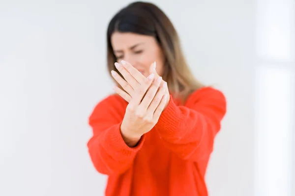 年轻女子穿着休闲红色毛衣在孤立的背景下遭受疼痛的手和手指 关节炎炎症 — 图库照片