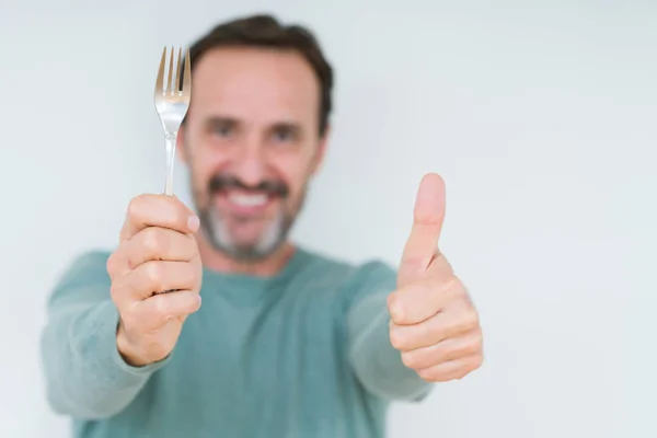 Hombre Mayor Sosteniendo Tenedor Plata Sobre Fondo Aislado Feliz Con —  Fotos de Stock