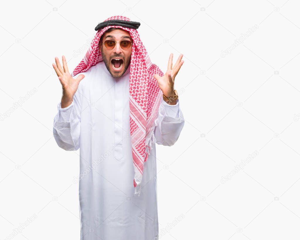 Young handsome man wearing keffiyeh over isolated background celebrating crazy and amazed for success with arms raised and open eyes screaming excited. Winner concept
