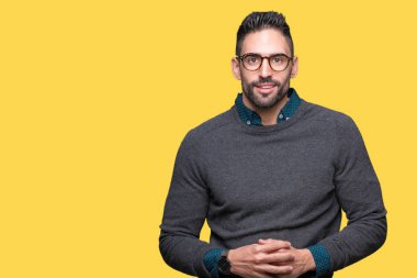 Arka plan eller üzerinde gözlük takan genç yakışıklı adam birlikte izole ve rahat ve neşeli gülümseyen parmak çarpı işareti. Başarı ve iyimser