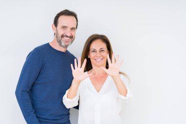 Güzel orta yaş kaç aşk gösterilen ve parmakları ile işaret izole arka plan üzerinde içinde number ten kendinden emin ve mutlu gülümseyerek süre.