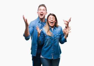 Kızgın ve çığlık kaldırdı ve kapalı gözleri heyecanlı silah ile başarı için deli kutluyor izole arka plan üzerinde aşık genç bir çift. Kazanan kavramı