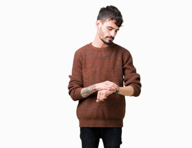 Kol saati, rahat ve kendinden emin zamanında kontrol izole arka plan üzerinde kış kazak giyen genç yakışıklı adam