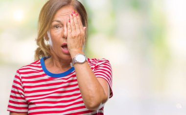 Orta yaş bir göz ile yüz ve sürpriz duygu kendinden emin gülümseme ile el kapsayan izole arka plan üzerine İspanyol kadın kıdemli.