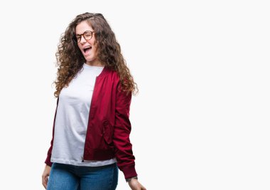 Güzel esmer kıvırcık saçlı Genç kız seksi bir ifadeyle, neşeli ve mutlu yüzünü kameraya bakarak göz kırpıyor izole arka plan üzerinde ceket ve gözlük takıyor.