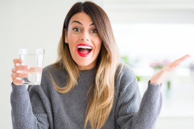 Evde çok mutlu ve heyecanlı, kocaman bir gülümseme ile çığlık zaferini kutluyor kazanan ifade su içme ve ellerini kaldırdı genç güzel kadın