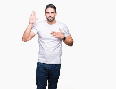 Yakışıklı adam beyaz üzerinde beyaz t-shirt giyen izole arka plan göğüs ve bir sadakat sözü yemin yapma avuç, el ile küfür