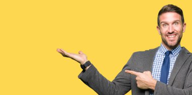 Yakışıklı iş adamı giyen uygun ve el ile sunulması ve parmak ile işaret ederken hayret ve gülümseyerek kameraya bağla.