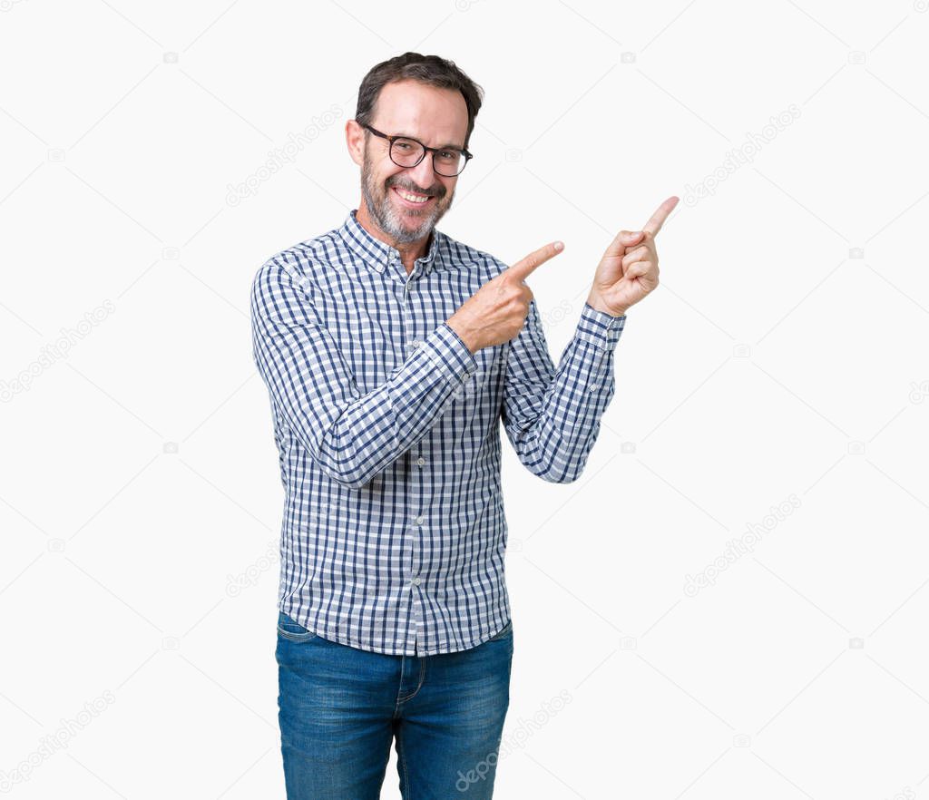 Handsome middle age elegant senior business man wearing glasses over isolated background smiling and looking at the camera pointing with two hands and fingers to the side.