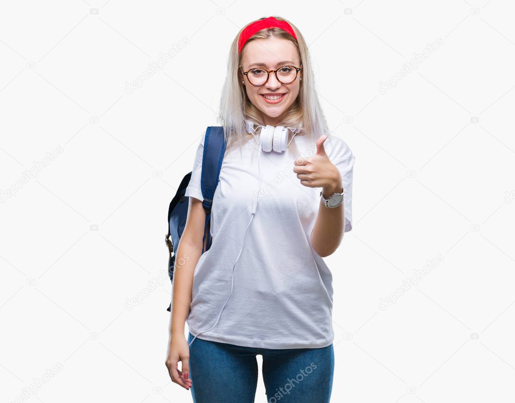 Young blonde student woman wearing glasses and backpack over isolated background doing happy thumbs up gesture with hand. Approving expression looking at the camera with showing success.