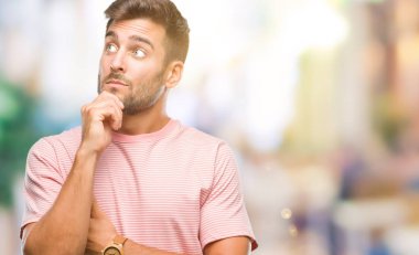 Yakışıklı delikanlı çene düşünme hakkında soru, dalgın ifade üzerine el ile izole arka plan üzerinde. Düşünceli yüzüyle gülümsüyor. Şüphe kavramı.