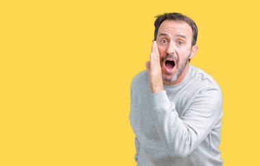 Yakışıklı orta yaş komuta sizde izole arka plan üzerinde bir kazak giyen el gizli söylenti söylüyor Ağızdan kötü amaçlı konuşma konuşma fısıldayan