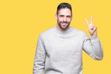 Gösterilen arka plan üzerinde sweatshirt giyen genç yakışıklı adam izole ve parmakları ile işaret kendinden emin ve mutlu gülümseyerek ise ikinci.