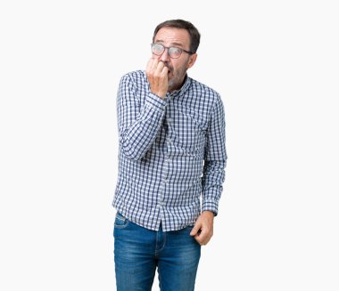 Stresli ve gergin elle çivi ısırma ağzına bakarak izole arka plan üzerinde gözlük takan yakışıklı orta yaş zarif üst düzey iş adamı. Anksiyete sorunu.