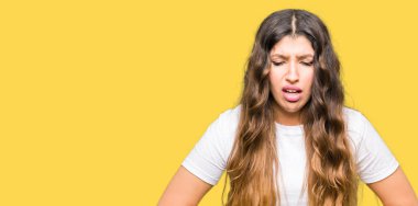 Çünkü mide üzerinde el ile rahat beyaz t-shirt giyen genç güzel kadın hazımsızlık, ağrılı hastalık hasta hissediyor. Ağrısı kavramı.