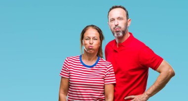 Orta yaş İspanyol çift komik surat ile yanakları şişirme izole arka plan üzerinde aşık. Ağız ile hava, deli ifade şişirilmiş.