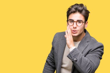 Genç iş adamı gözlük izole arka plan üzerinde kötü amaçlı konuşma konuşma fısıldayan gizli söylenti söylüyor dudaklarından el