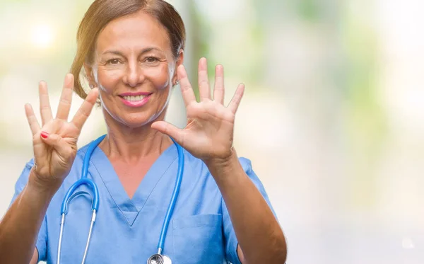 孤立した背景表示と指で上向きに中年看護師が先輩医師女性ナンバー ナイン自信を持って 幸せな笑みを浮かべて — ストック写真