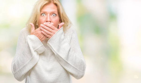 冬のセーターを着て中年の金髪女性は ミスのため手で口を覆っているショックを背景を隔離しました 秘密の概念 — ストック写真