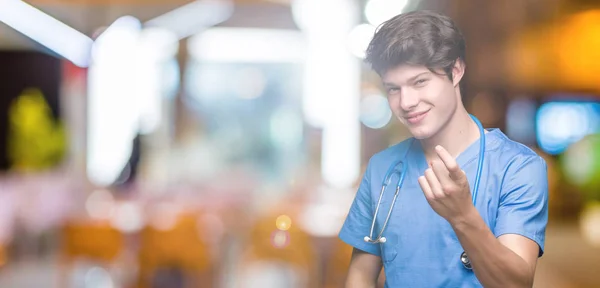Νεαρός Γιατρός Φορώντας Ιατρική Στολή Πέρα Από Απομονωμένο Υπόβαθρο Νεύοντας — Φωτογραφία Αρχείου