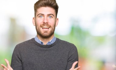 Genç yakışıklı zarif adam deli ve silah ile başarı için hayran kutluyor kaldırdı ve açık gözleri çığlık heyecanlı. Kazanan kavramı