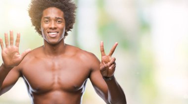 Afro Amerikalı gömleksiz adam çıplak vücut gösterilen ve parmakları ile işaret izole arka plan üzerinde gösterilen kendinden emin ve mutlu gülümseyerek süre yedi numara.